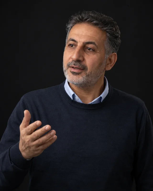 A teacher explaining with one hand raised